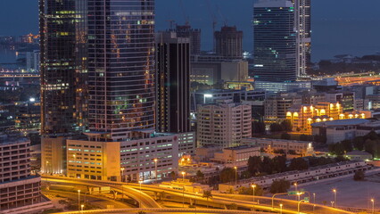 Fototapeta na wymiar Office buildings in Dubai Internet City and Media City district aerial night to day timelapse
