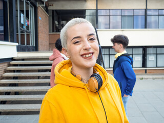 Portrait of a smiling alternative young woman with short hair looking at camera