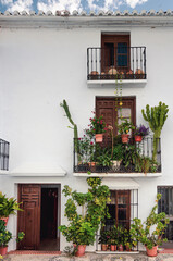 Casa de pueblo blanco de Andalucía, España con balcones y plantas tropicales