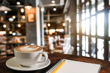  Coffee aroma in cup breakfast morning drink on wooden table in cafe shop with note pad and newspaper restaurant