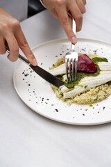 Couscous with fish fillet and beet on a white plate,