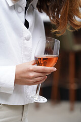Female hand holding glass of rose wine, outdoor