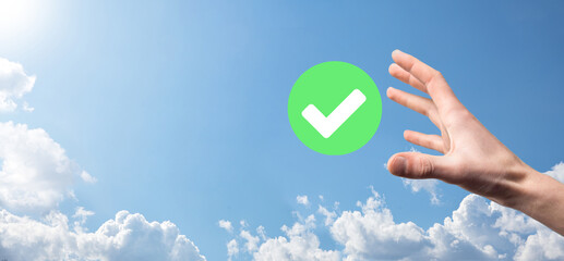 Hand holds green icon Check mark,Check Mark Sign, Tick Icon,right sign,circle green checkmark button,Done.On dark background.Banner.Copy space.Place for text.