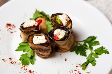 Cold appetizer of eggplant rolls with cheese and vegetables
