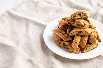 Homemade Italian Cantuccini with Chocolate on a White Plate, side view. Crispy Chocolate Cookies. Copy space.