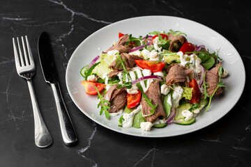 Beef tongue salad with fresh vegetables. Serving food in a restaurant. Photo for the menu