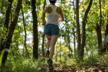 Woman runner running on forest trail