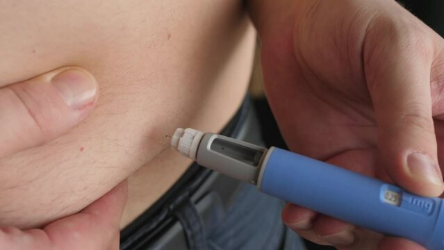 obese fat man preparing Semaglutide Ozempic injection to control blood sugar levels