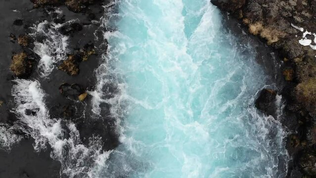 Glacial meltwater rushing through narrowing in river stream in Iceland