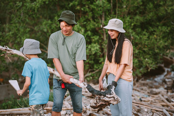 Teamwork of asian family environment conservation volunteer help to keep and clean up garbage and lumber to protect bushfire on forest area.Volunteering save world concept.