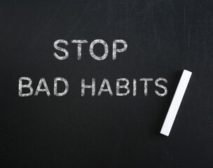 Phrase Stop Bad Habits and piece of chalk on blackboard, top view