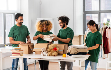 charity, donation and volunteering concept - international group of happy smiling volunteers...