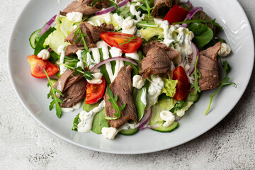 Beef tongue salad with fresh vegetables. Serving food in a restaurant. Photo for the menu