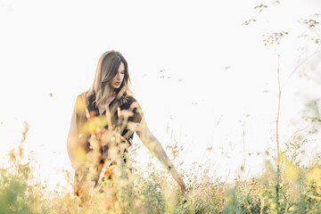 Mature middle age attractive pregnant woman in brown dress at summer field.