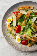 French salad Nicoise with tuna, egg, green beans, tomatoes, olives, lettuce, onions and anchovies on a white background. Healthy food