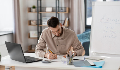 distance education, remote job and stress concept - male teacher with laptop computer working at home office