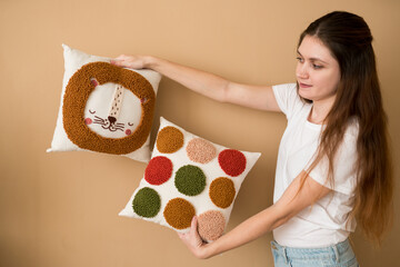 Cheerful woman holding pillows. Punch needle embroidery pillow diy. Product is made according to...