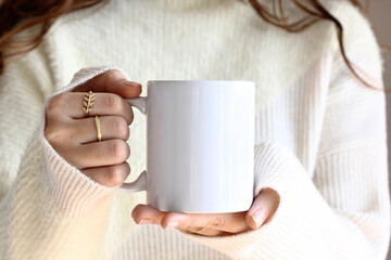Girl is holding white mug in hands. Blank 11 oz ceramic cup