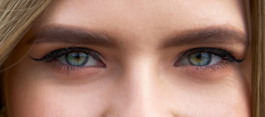 Obraz premium Close-up face of pretty girl with beautiful big blue and green eyes. Big eyelashes and eyebrows.