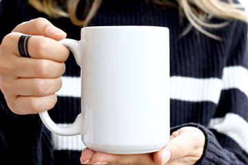 Girl is holding white cup in hands. 15 oz mug in woman's hands.