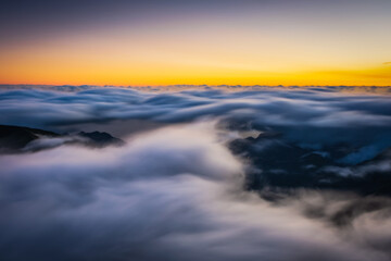 Fototapeta na wymiar Mountain trail Pico do Arieiro, Madeira Island, Portugal Scenic view of steep and beautiful mountains and clouds during sunrise. October 2021. Long exposure picture