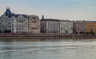 Fototapeta na wymiar Exterior view of historical old town buildings and River Danube in the downtown of Budapest, Hungary, Europe. Panoramic riverside, European capital city skyline. Colorful houses along the quayside.