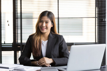 Portrait of a business woman secretary or office consultant working on a laptop.