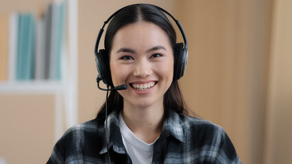 Close up portrait web cam view asian business woman wears headset talks to camera making distance...