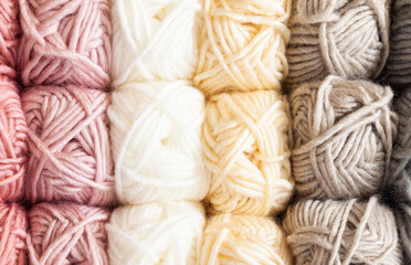Clews of threads for knitting of different colors are stacked on the shelves, close-up.