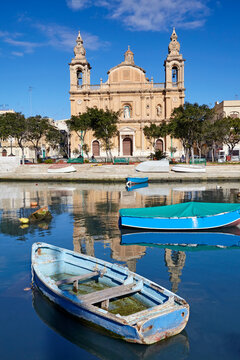 Msida Parish church reflected in  St George's harbour during the morning