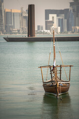 Doha,Qatar- April 24,2022 :  Traditional dhow boats with the futuristic skyline of Doha in the background.