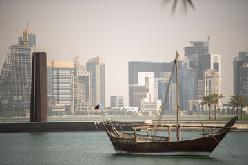 Doha,Qatar- April 24,2022 :  Traditional dhow boats with the futuristic skyline of Doha in the background.