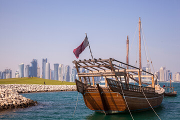 Fototapeta premium Doha,Qatar- April 24,2022 : Traditional dhow boats with the futuristic skyline of Doha in the background.