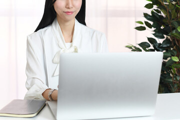 笑顔でパソコン操作するアジア人の女性