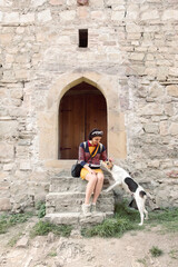 Young happy travel girl feed homeless stray dog.