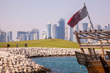 Naklejka premium Doha,Qatar- April 24,2022 : Traditional dhow boats with the futuristic skyline of Doha in the background.