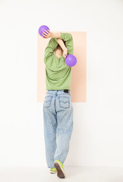 Woman with purple balloons standing against white background