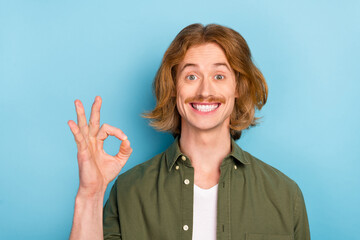 Portrait of attractive cheerful red-haired guy showing ok-sign ad advert solution isolated over...