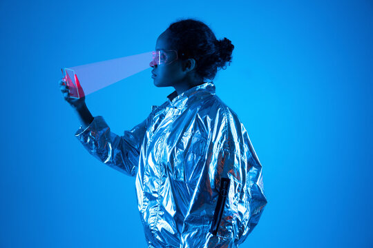 Woman wearing smart glasses scanning futuristic smart phone against blue background