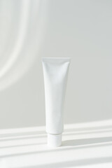 White cream tube cosmetics container mockup on white background. Beauty and medicine mockup with shadows. Minimalist modern mockup