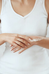 Closeup of female hands applying hand cream.Hand Skin Care. Girl hands with french manicure.