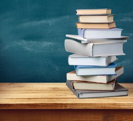 Stack of books on wooden desk