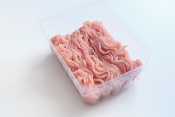 Minced meat in a transparent plastic container. Fresh pork minced meat, on white background.
