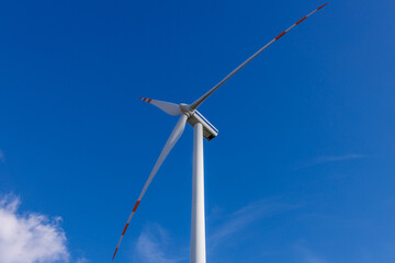 Turbina wiatrowa na tle nieba z perspektywy dolnej. Ekologiczne rozwiązania energetyczne źródeł odnawialnych. 