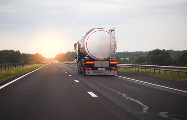 A truck with a semi-trailer transports a dangerous chemical cargo in a tank car on a highway...