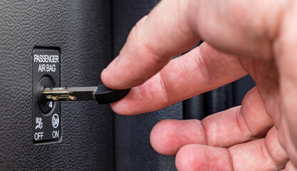 Man turns off front passenger airbag with key, macro