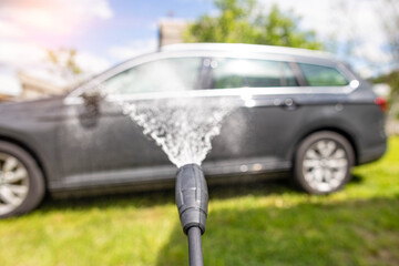 Car wash with modern car shampoo using a high pressure washer in summer. Background, cleaning cars...