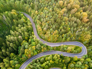 Winding road from high mountain pass, in summer time. Aerial view by drone. Romania
