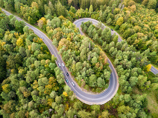 Winding road from high mountain pass, in summer time. Aerial view by drone. Romania