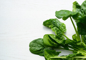 Fresh spinach on white wooden background. Green spinach leaves, top view, copy space
